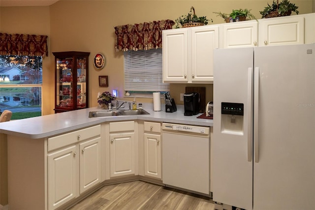 kitchen featuring kitchen peninsula, white appliances, white cabinetry, and sink