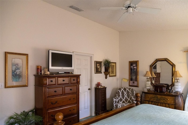 bedroom with a textured ceiling, vaulted ceiling, and ceiling fan