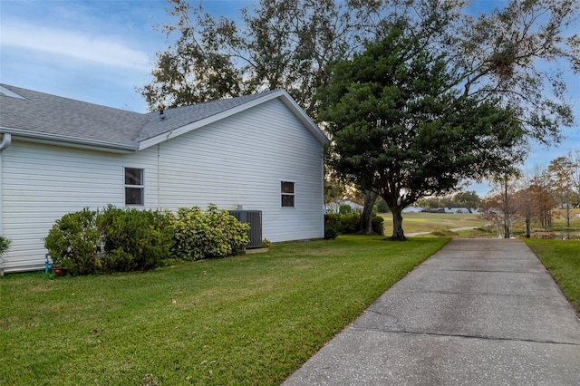 view of side of property featuring a yard and central AC unit