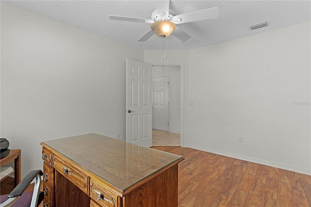 office space featuring a textured ceiling, ceiling fan, and light hardwood / wood-style flooring