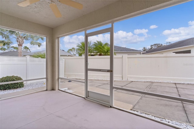 unfurnished sunroom featuring ceiling fan