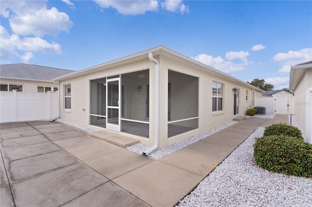 rear view of house with a patio area, cooling unit, and a sunroom