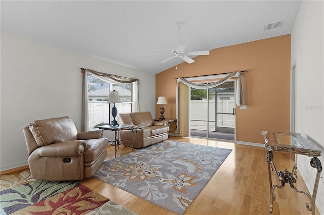 living room with light wood-type flooring, vaulted ceiling, and ceiling fan