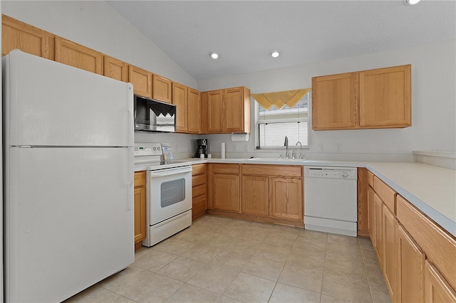 kitchen with sink, white appliances, vaulted ceiling, and light tile patterned floors