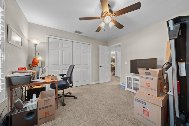 carpeted office space featuring ceiling fan