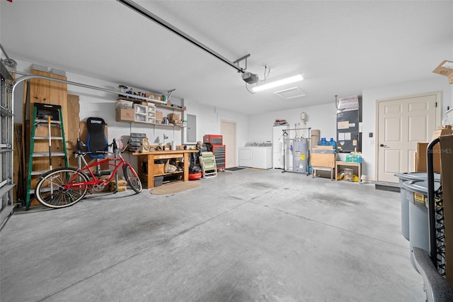 garage featuring a workshop area, water heater, a garage door opener, electric panel, and washer and dryer