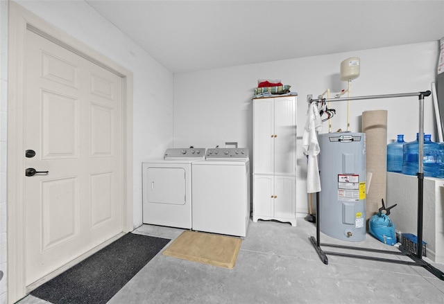 washroom with cabinets, electric water heater, and washing machine and dryer