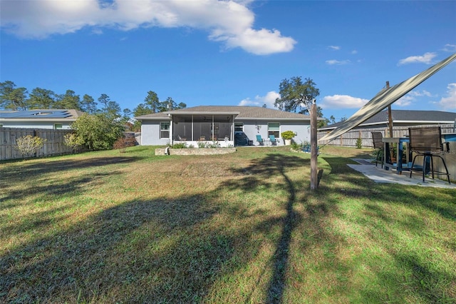 back of house with a lawn and a patio