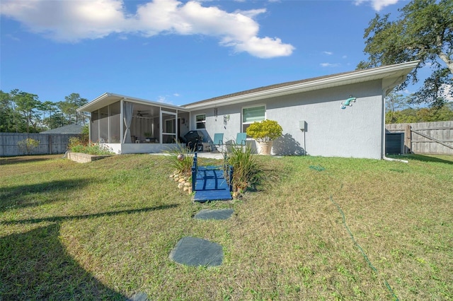 rear view of house with a sunroom and a lawn