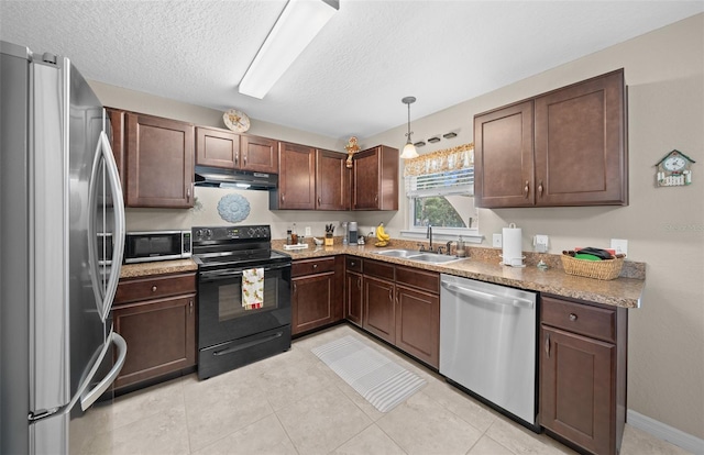 kitchen with sink, hanging light fixtures, light tile patterned floors, a textured ceiling, and appliances with stainless steel finishes