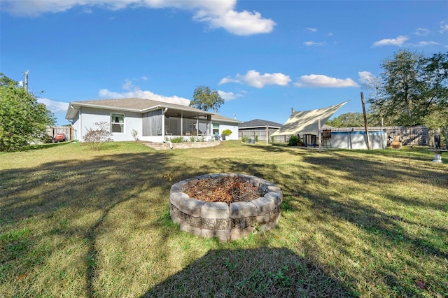 view of yard with a sunroom and an outdoor fire pit