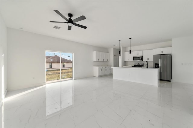 unfurnished living room with ceiling fan and sink