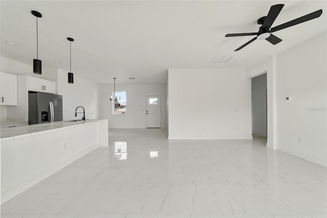 unfurnished living room with ceiling fan and sink