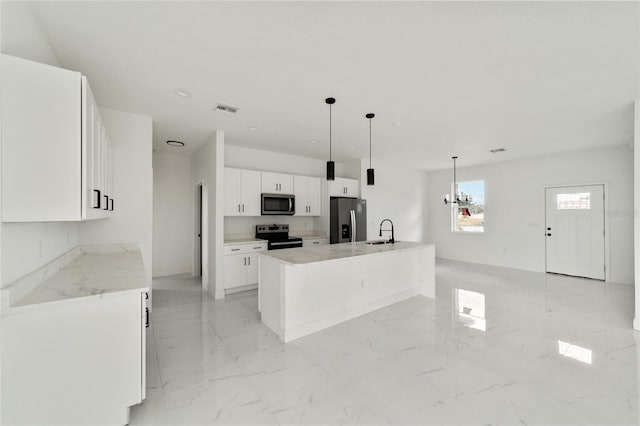 kitchen with pendant lighting, white cabinets, sink, an island with sink, and stainless steel appliances