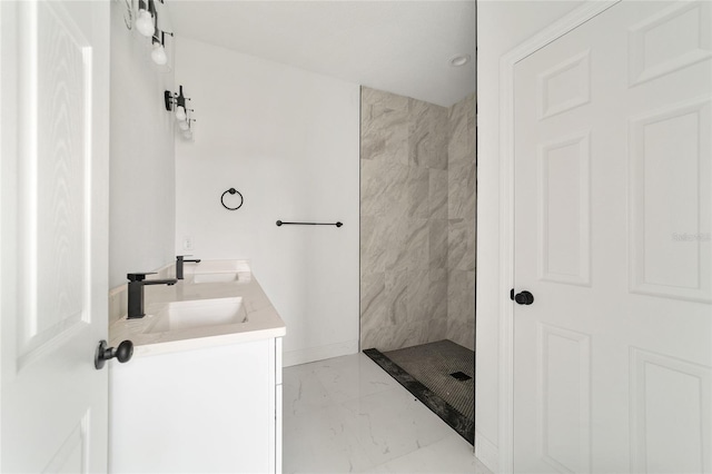 bathroom featuring tiled shower and vanity