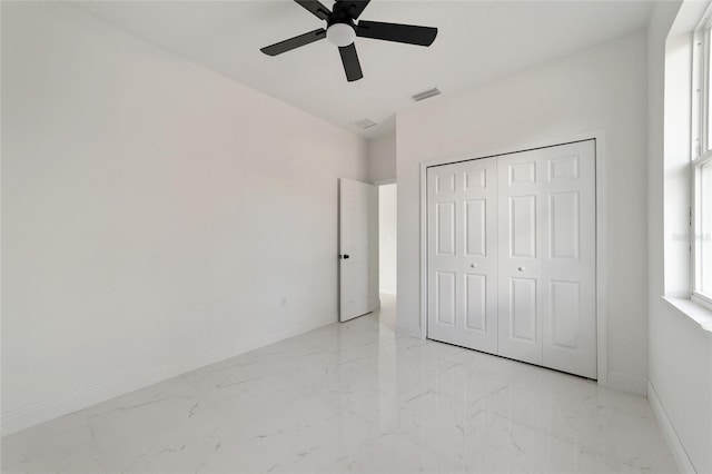 unfurnished bedroom featuring ceiling fan and a closet