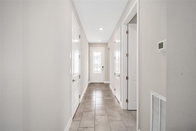 hall featuring light tile patterned floors