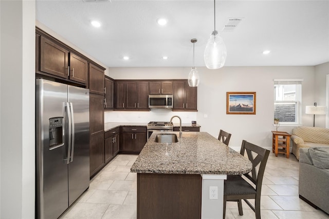 kitchen featuring dark brown cabinets, sink, a kitchen bar, and stainless steel appliances