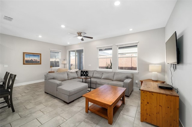 living room featuring ceiling fan and a healthy amount of sunlight