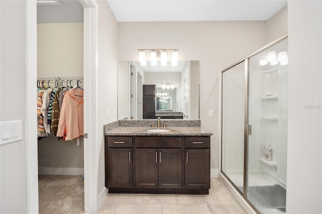 bathroom with tile patterned floors, vanity, and a shower with shower door