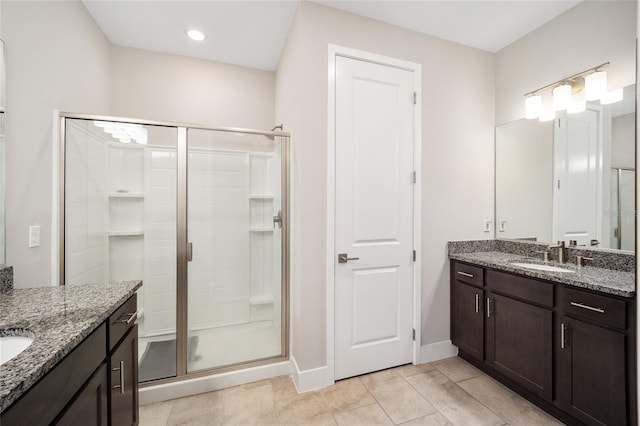 bathroom with tile patterned flooring, vanity, and walk in shower