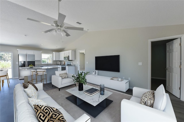 living room with ceiling fan, light hardwood / wood-style floors, lofted ceiling, and a wealth of natural light