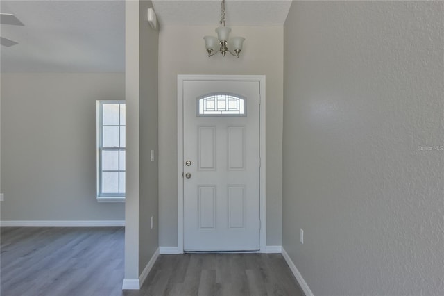 foyer entrance featuring light wood-type flooring and an inviting chandelier