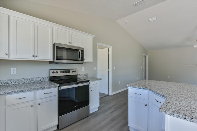 kitchen with appliances with stainless steel finishes, light wood-type flooring, ceiling fan, white cabinets, and lofted ceiling