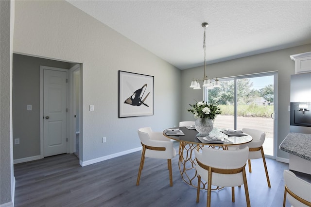 dining room with a chandelier, a textured ceiling, vaulted ceiling, and dark wood-type flooring