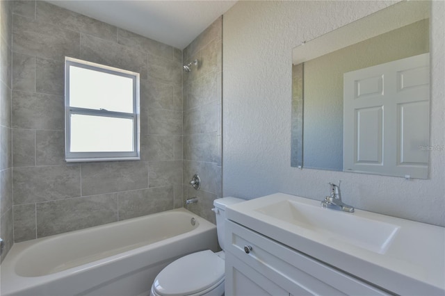 full bathroom featuring vanity, tiled shower / bath combo, and toilet