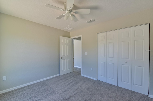 unfurnished bedroom with ceiling fan, a closet, and carpet