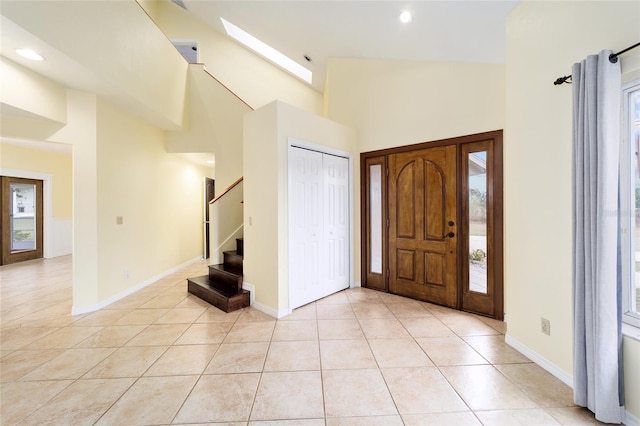 entrance foyer with high vaulted ceiling and light tile patterned floors