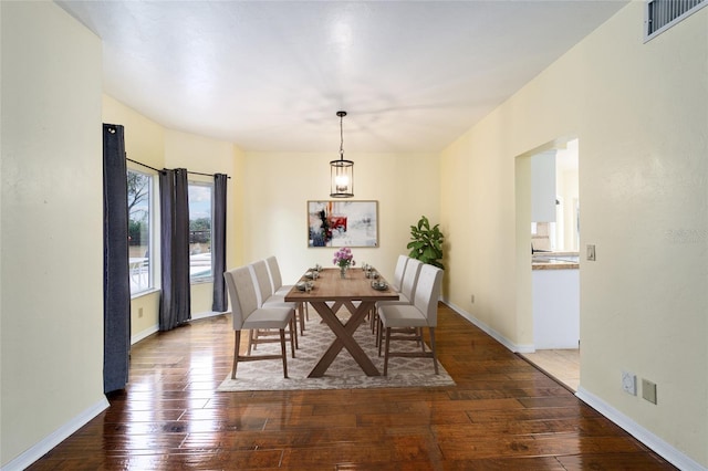 dining space featuring dark hardwood / wood-style flooring and an inviting chandelier