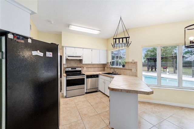 kitchen with stainless steel appliances, tasteful backsplash, kitchen peninsula, pendant lighting, and white cabinets