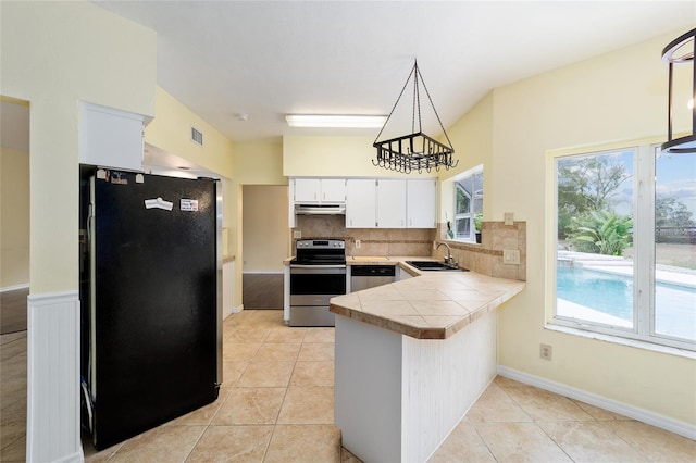 kitchen with kitchen peninsula, decorative light fixtures, decorative backsplash, white cabinets, and appliances with stainless steel finishes