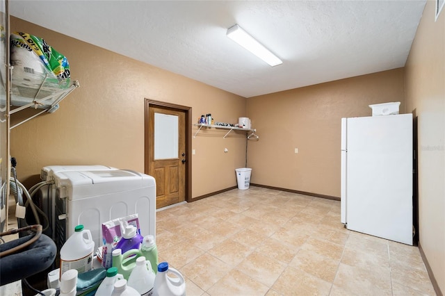 laundry room featuring washer and clothes dryer and a textured ceiling