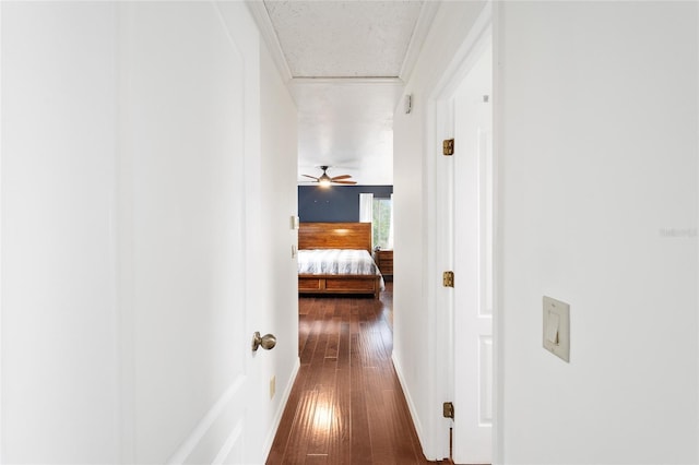 hall with ornamental molding and dark wood-type flooring