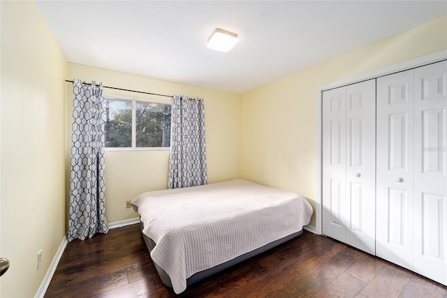 bedroom with dark hardwood / wood-style floors and a closet