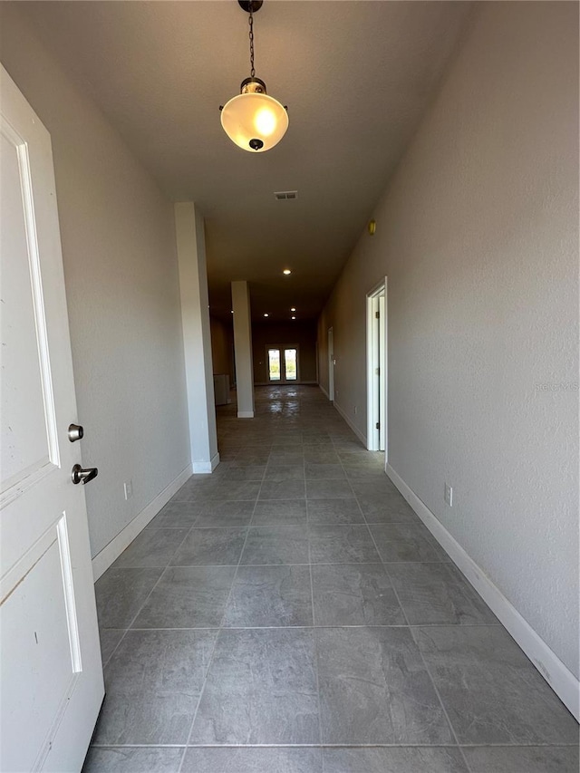 hall featuring dark tile patterned flooring