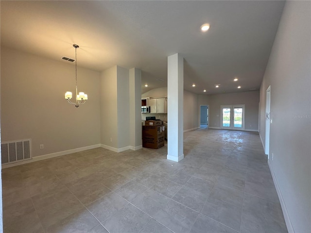 empty room with french doors, light tile patterned flooring, and a notable chandelier