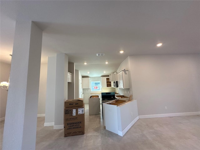 kitchen featuring white cabinets, black gas range, light tile patterned flooring, and kitchen peninsula