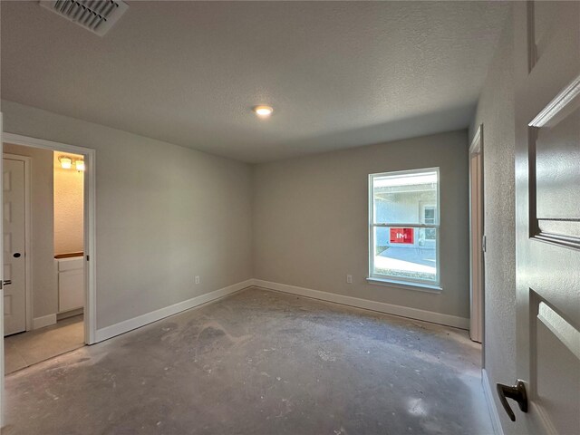 unfurnished room featuring concrete flooring and a textured ceiling