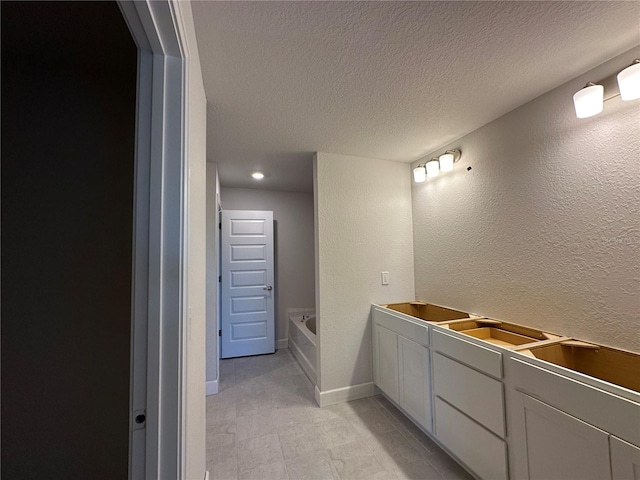 bathroom with a bath and a textured ceiling