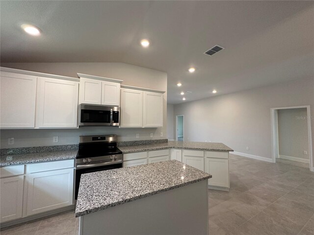 4445 SW 90th Pl, Ocala, FL 34476 - kitchen with stainless steel appliances, a peninsula, white cabinets, light stone counters, and recessed lighting