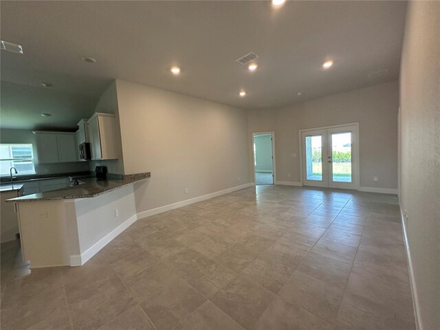 4445 SW 90th Pl, Ocala, FL 34476 - kitchen with stainless steel microwave, dark stone countertops, recessed lighting, open floor plan, and a peninsula