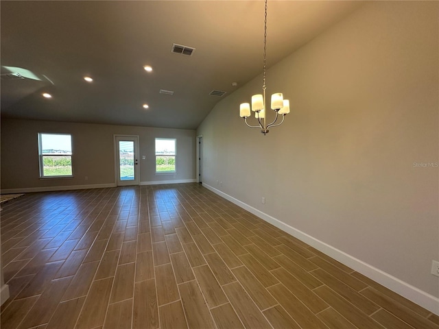 unfurnished room featuring vaulted ceiling, dark hardwood / wood-style floors, and an inviting chandelier