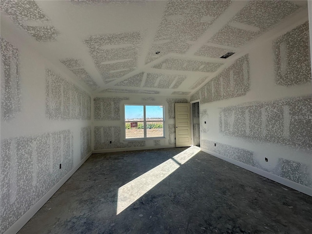 empty room featuring vaulted ceiling