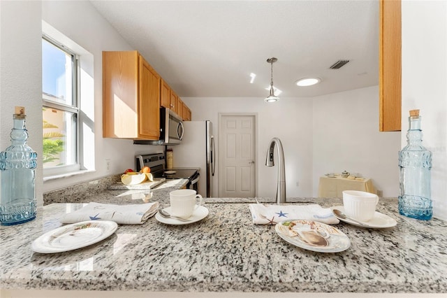 kitchen with pendant lighting, light stone counters, and stainless steel appliances