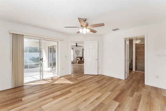 unfurnished room with a textured ceiling, ceiling fan with notable chandelier, and light hardwood / wood-style floors