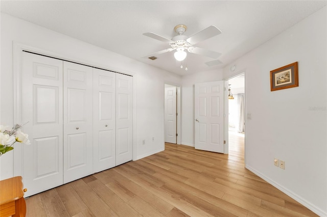 unfurnished bedroom featuring ceiling fan, light hardwood / wood-style flooring, and a closet